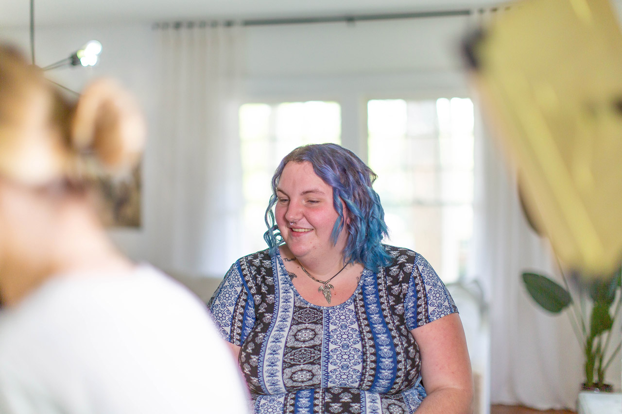 Women with blue hair smiling before her Tampa boudoir photography session