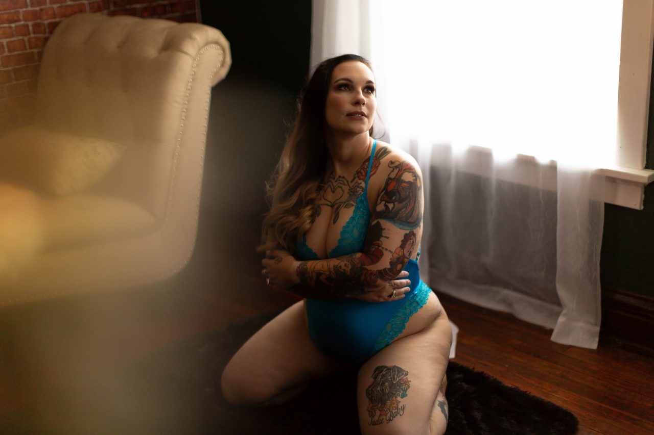 Brunette woman with tattoos poses for a classic boudoir photo session with Boudoir by Cipriani in Tampa, FL